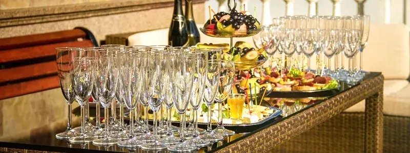高級シャンパングラスとフィンガーフードが並ぶラグジュアリーなパーティーテーブル。特別なシーンでシャンパンを楽しむイメージ。