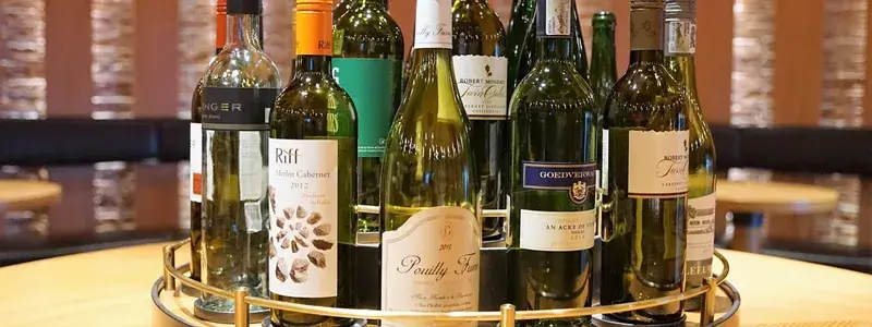 テーブルに並べられた複数のワインボトル。ストーンズジンジャーワインの代替品として楽しめるおすすめワインやリキュールをイメージ。