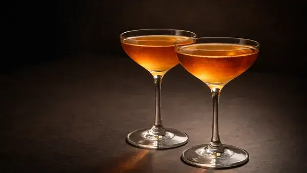 グランドスラムのカクテル。落ち着いたアンバーカラーの2杯が静かな空間に並び、ふたりだけの秘密や特別なつながりを表現したイメージ画像