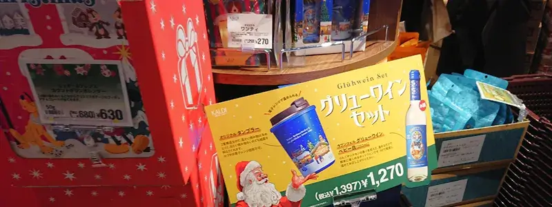 カルディ店頭に並ぶ2025年グリューワインセット。オリジナルタンブラーと白ワインのPOPが掲示されている様子