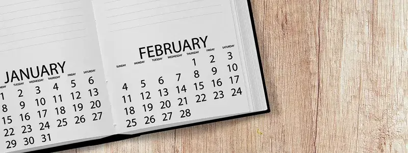 机に開かれたカレンダー付きのメモ帳