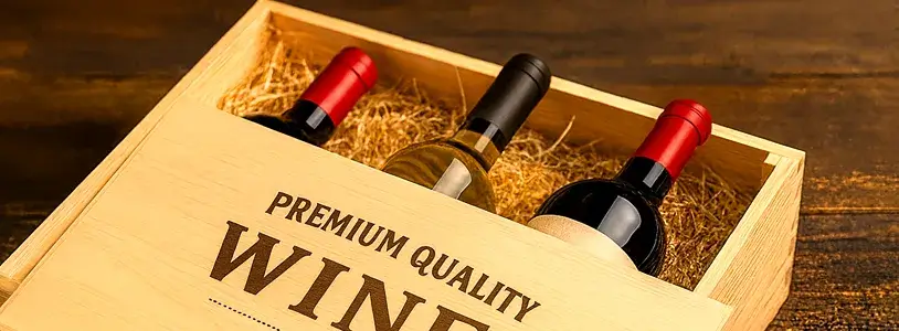 木箱のフタが半分開いた状態で、赤白ワインのボトルが並ぶ高級感あるギフトボックスの写真