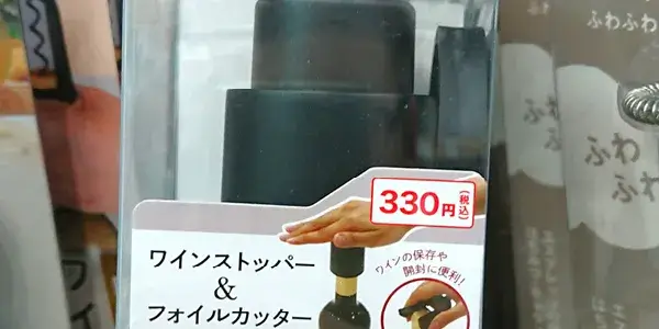 セリアの店頭で見つけたワインストッパー&フォイルカッターの写真。黒色の本体で、税込330円の商品ラベルが付いている。ワインの保存や開封に便利な実店舗での取扱い例を示した画像