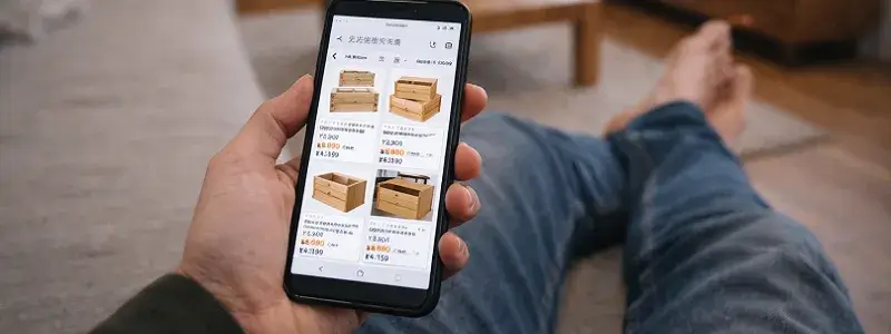 自宅のソファでくつろぎながらスマホでワイン箱の代替手段を探しているイメージ