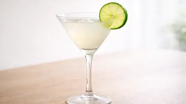 XYZのカクテル。ライムを添えた淡く白濁した一杯が、永遠にあなたのものという意味を感じさせるシンプルで清潔感のあるイメージ画像